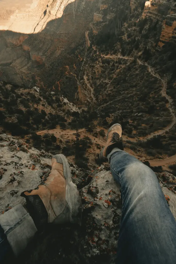 buty trekkingowe wiszące nogi nad przepaścią